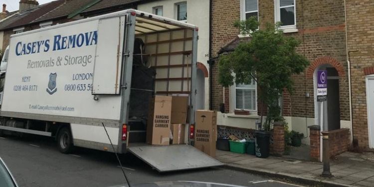 Removals truck outside house with rear door open, with writing that says " Casey's Removals"