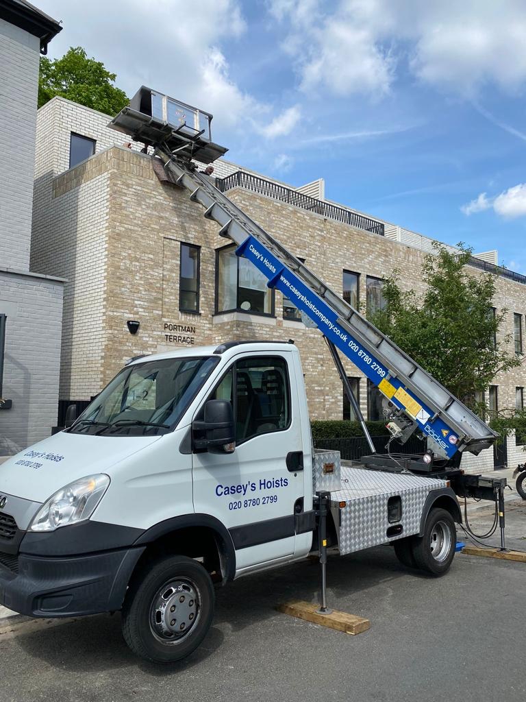 Casey's Removals Truck with furniture hoist in full stretch next to house