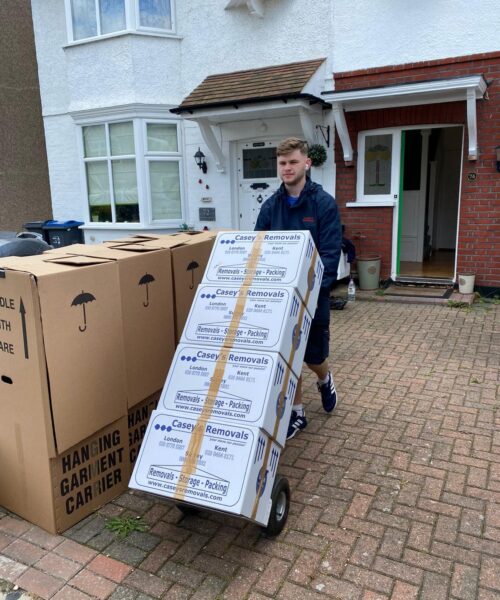 Removal man moving casey's removal boxes on trolley outside out